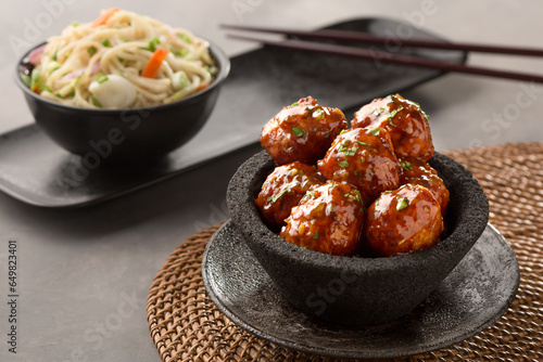veg manchurian with hakka noodles and chopsticks served in bowl side view of chinese food photo