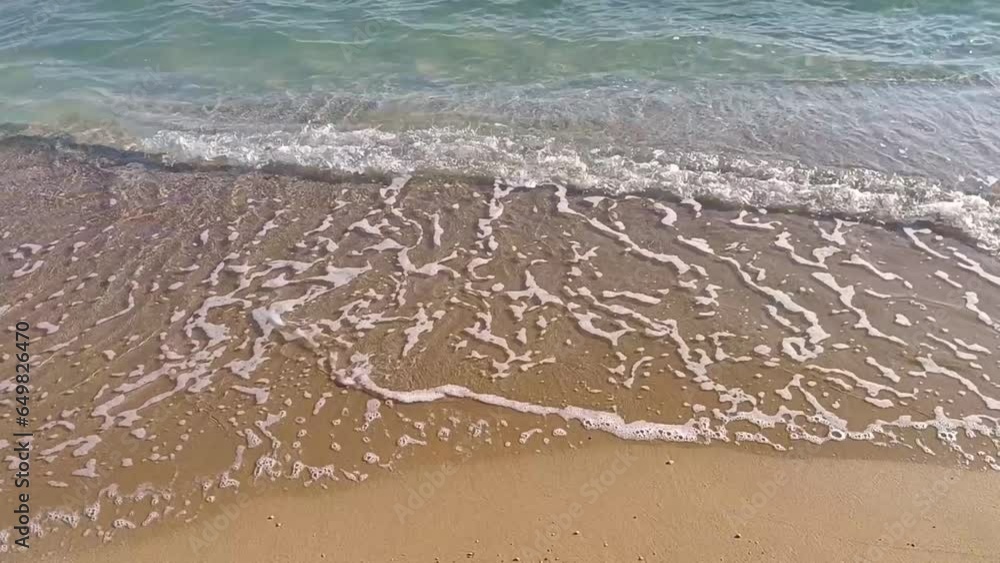 Foaming waves breaking on the sandy beach. Handheld shot. Close-up. Foaming waves breaking on the sandy beach. Handheld shot. Close-up.