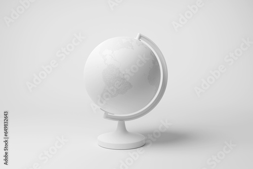 White desk globe on white background in monochrome and minimalism. Illustration of the concept of world travel destinations and vacations photo