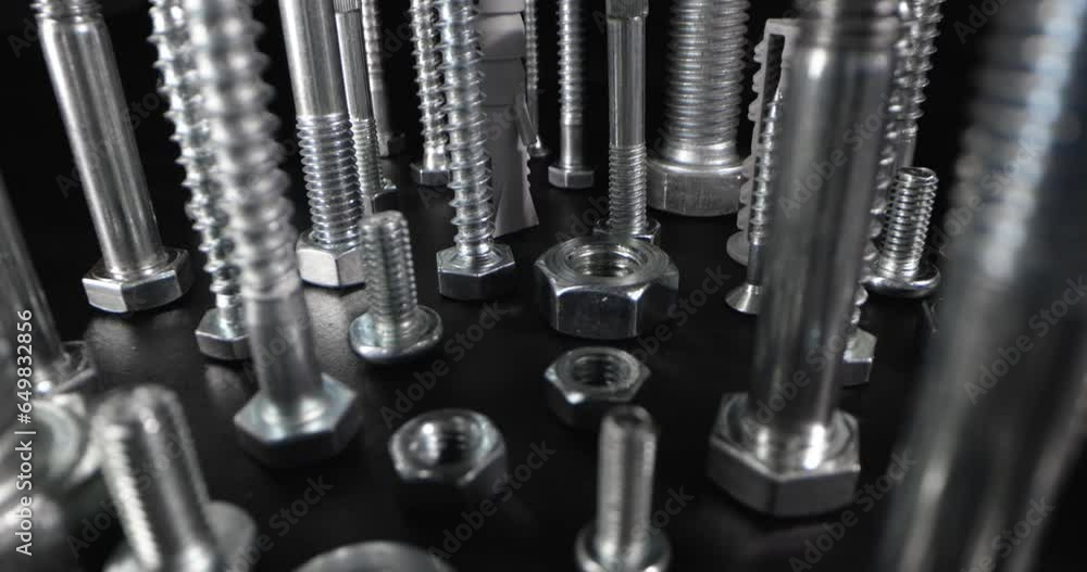 metal screws, bolts and fasteners on black background. slider shot metal screws, bolts and fasteners on black background. slider shot