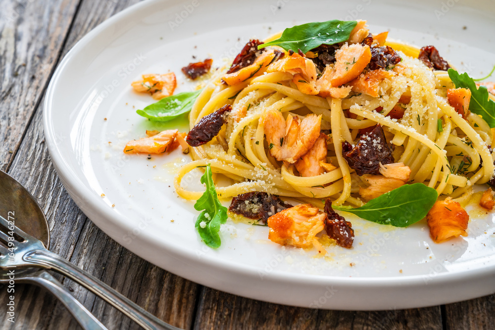 Linguine with salmon and sun dried tomatoes on wooden table
Linguine with salmon and sun dried tomatoes on wooden table