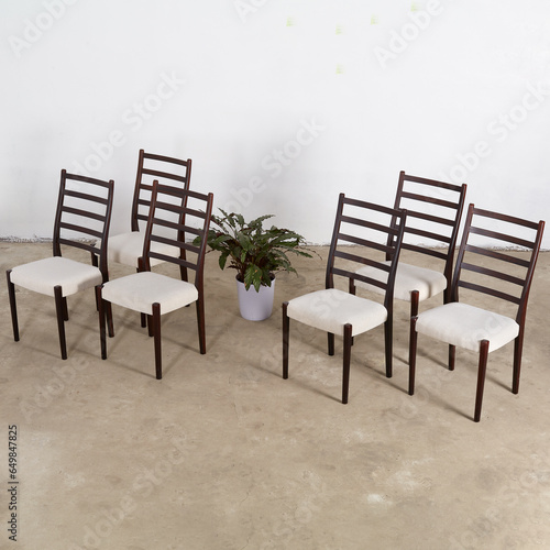 Set of elegant Mid-Century Modern rosewood dining chairs. Vintage dark wood ladderback chairs. Interior photograph.