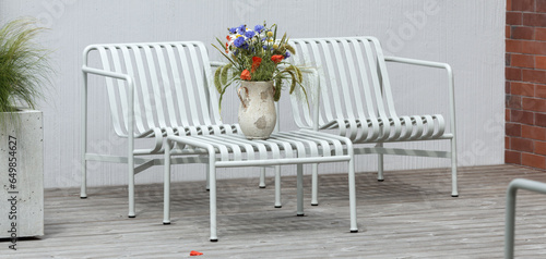 Wild flower bouquet (Cornflowers, chamomiles wheat and poppies) in terracotta vase on summer terrace. Wildflower and grass varieties.