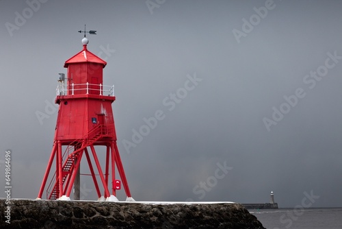 A Red Lighthouse Under A Stormy Sky Along The Coast; South Shields, Tyne And Wear, England photo