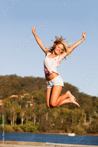 A Young Woman Jumps In The Air; Currumbin, Gold Coast, Queensland, Australia