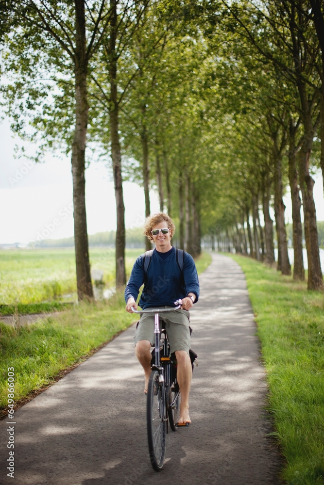 A Boy Riding His Bike Along The Dutch Canals; Houten, The Netherlands