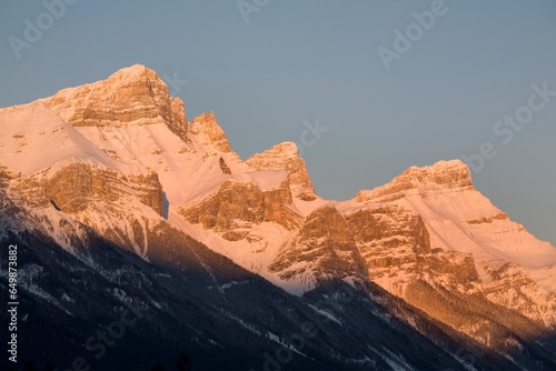 Sunlight Shining On Snow Covered Mountains Against A Blue Sky  Canmore, Alberta, Canada © Designpics