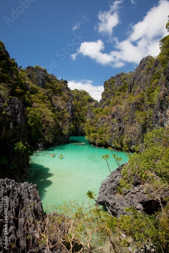 Tourists Kayak Inside The Scenic Small Lagoon On Miniloc Island, Near El Nido; Bacuit Archipelago, Palawan, Philippines