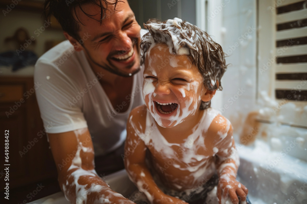 Father and son having fun in a bathroom, laughing happily with shaving foam on their faces. Young single dad taking a moment to bond and share moments of joy with his boy on father's day. - obrazy, fototapety, plakaty 