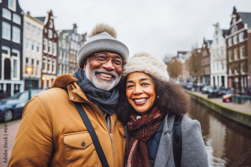 Multiethnic couple traveling in Amsterdam in autumn. Happy older travelers exploring in city.