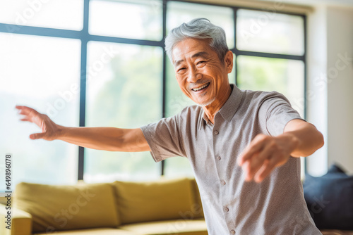 Positive chinese older man dancing at home. Happiness and well being concept.