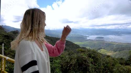 Caucasian woman looking at a landscape of the Cocha lagoon or Guamuez lake in Pasto Nariño Colombia. Fresh air and wind in the Latin American landscape photo