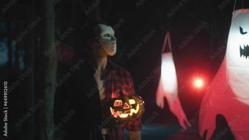 Masked man with halloween pumpkin walk in the forest Masked man with halloween pumpkin walk in the forest