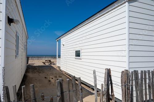 Beach holidays on sandy beach, waterfront wooden cottages in Katwijk-on-zee, North sea, Netherlands photo