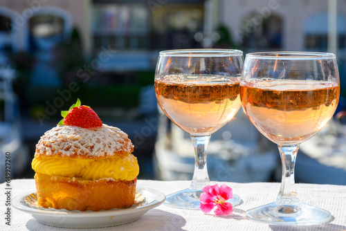 Wine and cake of French Riviera, glasses of cold rose Cote de Provence wine and Tarte Tropezienne cake in yacht harbour of Port Grimaud, summer vacation in Provence, France.