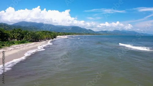 Hyperlapse Drone Footage of Tropical Coastline Journey – Soaring Over Palm Trees and Rugged Mountains on the Left, Azure Sea Stretching to the Horizon on the Right photo