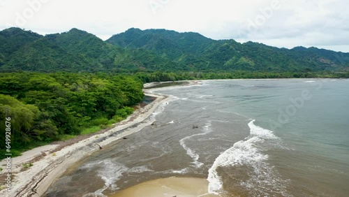 Captivating Drone Footage of Tropical Coastline Journey – Soaring Over Palm Trees and Rugged Mountains on the Left, Azure Sea Stretching to the Horizon on the Right p2 photo