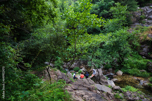 A group of people have a snack in the forest around the Belelle waterfall in Neda, Galicia photo