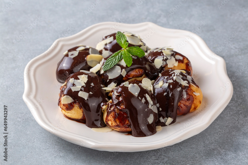 Delicious profiteroles with chocolate and white plate. Delicious profiteroles with chocolate and white plate.