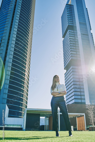 middle-aged female entrepreneur posing with office buildings in background