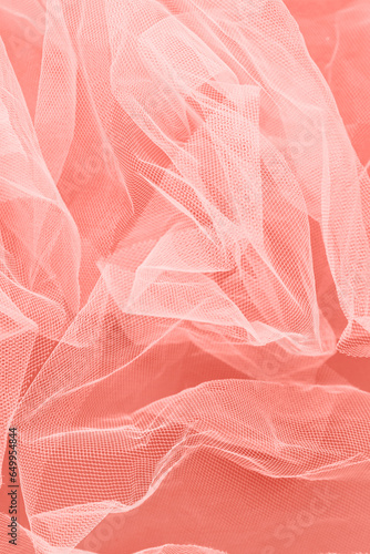 Crumpled veiling cloth on coral background