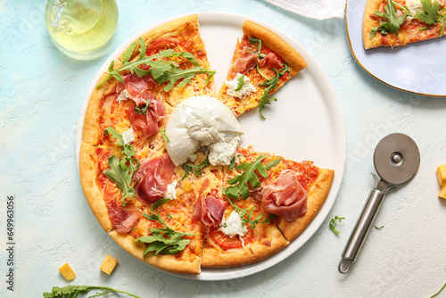 Plate of tasty pizza with Burrata cheese on blue background