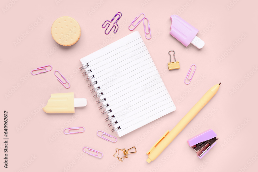 Notebook with different stationery supplies on pink background Notebook with different stationery supplies on pink background
