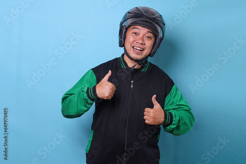 Excited Asian delivery man wearing helmet and jacket showing two thumbs up