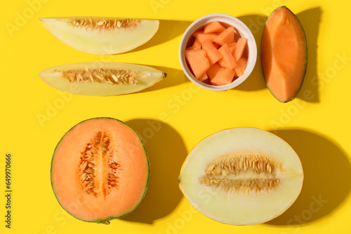 Sweet melons and bowl with pieces on yellow background