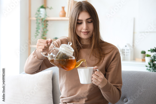 Young woman pouring hot tea...