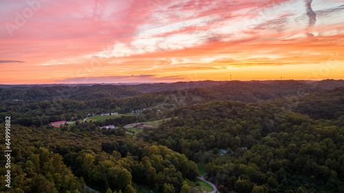 Golden Hour Glory: Aerial Perspective of a Forest Bathed in Sunset Hues.