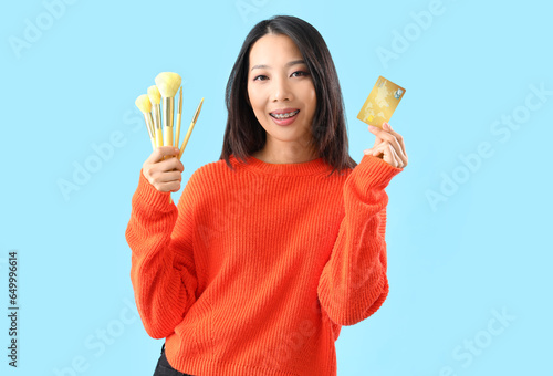 Young Asian woman with cred...