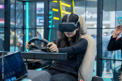 Tableau sur toile Woman wearing VR headset having fun while driving on car racing simulator