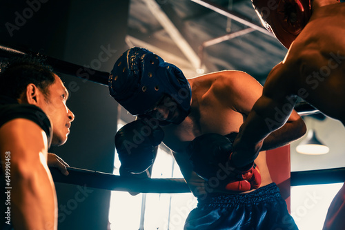 Boxer fighter competitor struggle with pain and disadvantage on boxing match at the ring while referee closely observe action. Boxer with safety helmet try to defense himself. Impetus © Summit Art Creations