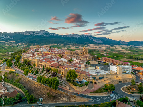 Obraz na płótnie Aerial view of Laguardia medieval fortified hilltop village surrounded by vineries in the Rioja region of Spain, with colorful sunset sky w salonie