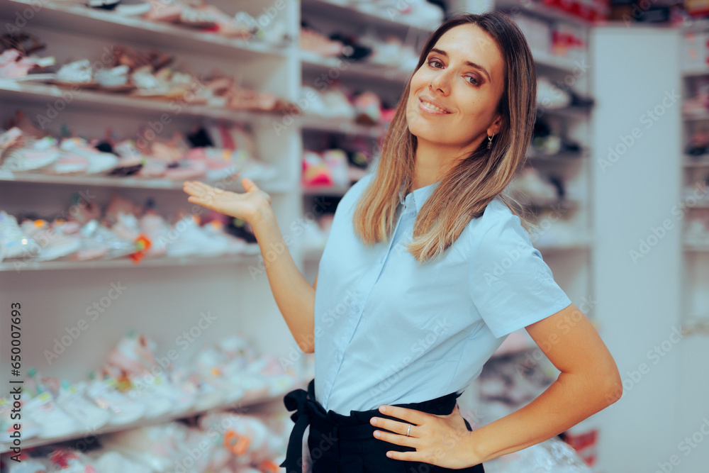 Shop Assistant Working in a Shoes Store Presenting her Merchandise. Cheerful promoter holding her palm to show retail merchandise 