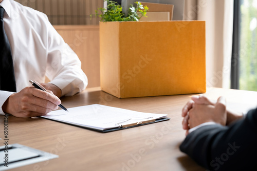 Man signing resignation letter.