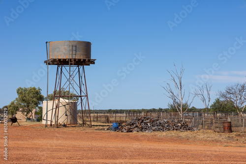 Water tanks and a wood pile in a farm yard in outback country in Australia. photo