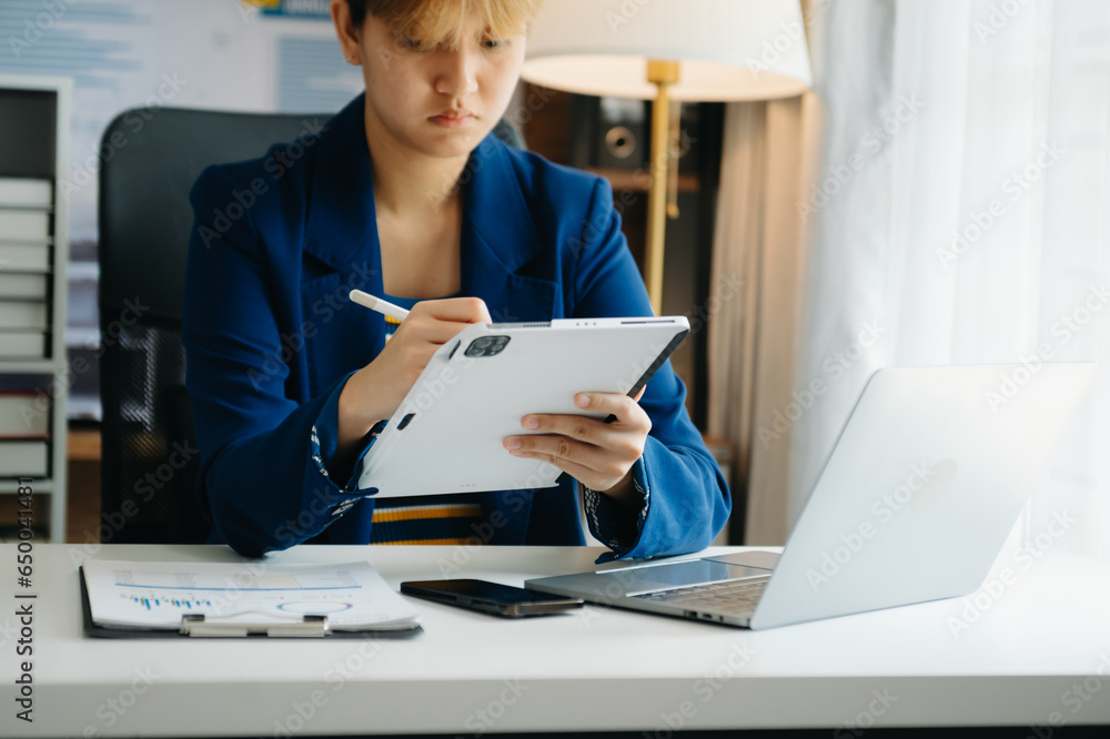 Woman freelancer is working her job on computer tablet and laptop Doing accounting analysis report real estate investment data, Financial at office. Woman freelancer is working her job on computer tablet and laptop Doing accounting analysis report real estate investment data, Financial at office.