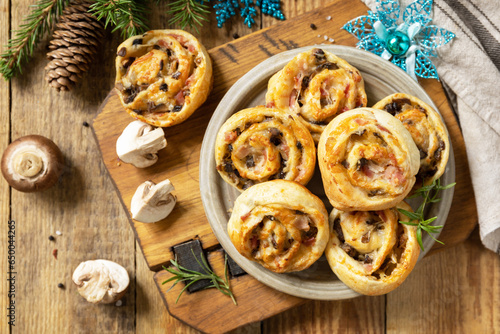 Fotografi Pizza rolls puff pastry stuffed with prosciutto bacon, mushrooms and cheese on the Christmas table, italian appetizers