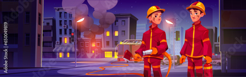 Two firefighters in front of fire in city. Men in uniform and helmet with hose, axe and extinguisher working to extinguish fire in house. Burning building in town and employees of emergency service.