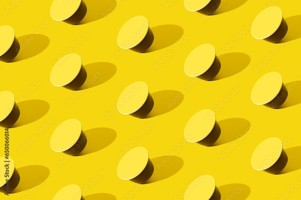 Espresso ground coffee capsule with yellow cover. Pattern on yellow background. Espresso ground coffee capsule with yellow cover. Pattern on yellow background.
