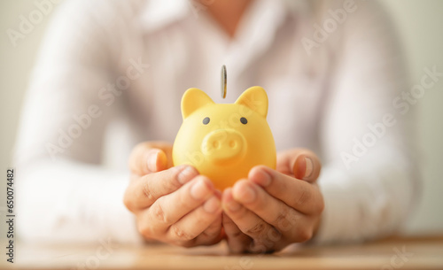Billede på lærred coins into piggy bank on hands for saving money, investment, success ,commission,  wealth and finance concept