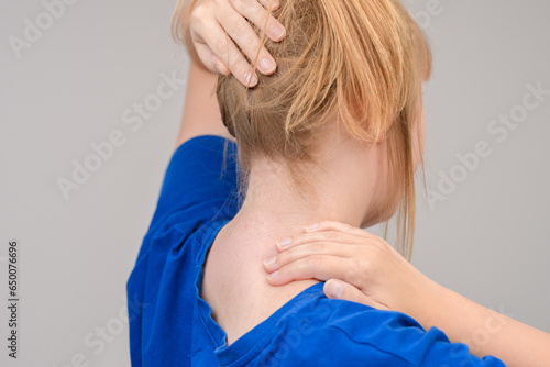 Kobieta dotykająca się w okolicach karku, ból  photo