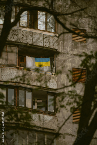 old abandoned building, Ukrainian flag, blue and yellow, flag on the balcony, street urban aesthetic