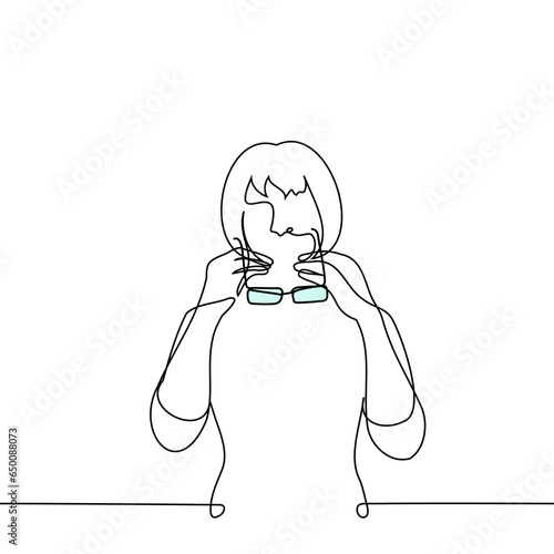 woman putting on or taking off glasses - one line art vector. concept of testing glasses, glasses for vision