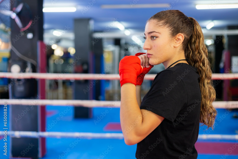 Female boxer portrait in guard position in a ring. Fighting sport training. Female boxer portrait in guard position in a ring. Fighting sport training.