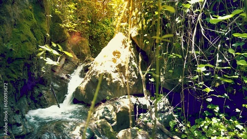 very beautiful waterfall with sunlight passing through the tree leaves in algeria photo