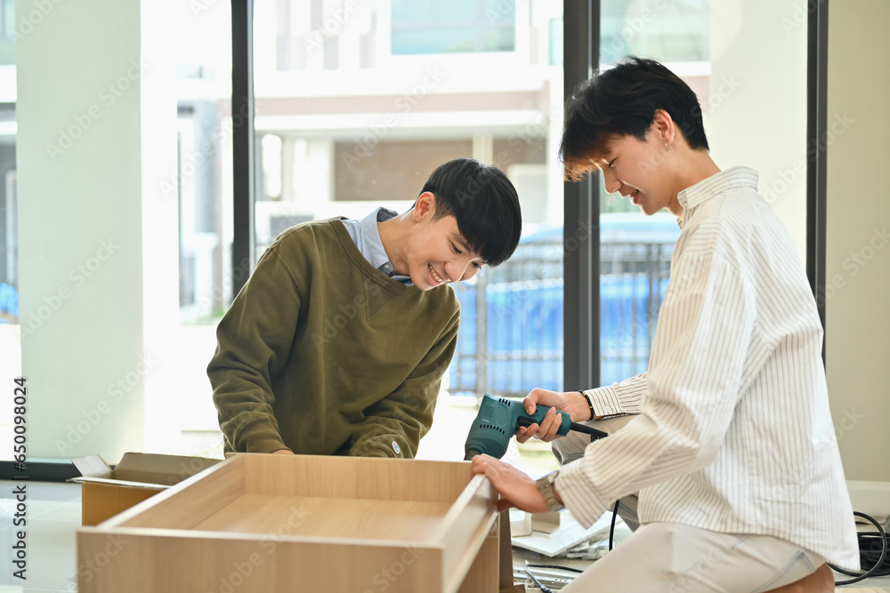 Asian gay couple assembling new furniture with screwdriver, moving house, relocation and real estate Asian gay couple assembling new furniture with screwdriver, moving house, relocation and real estate