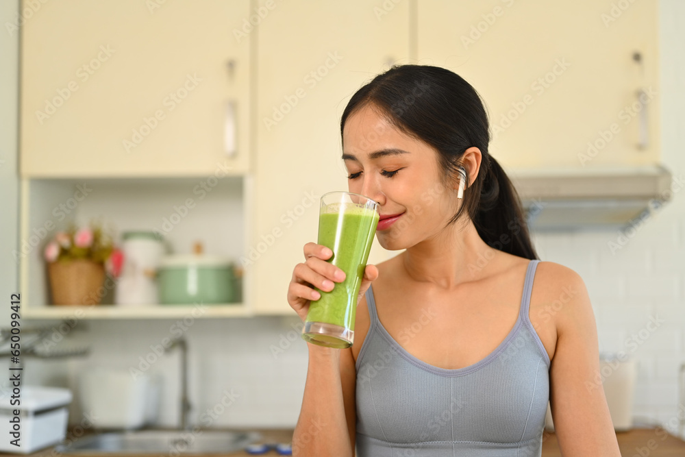 Charming young woman in sportswear drinking healthy vegetarian smoothie after morning workout. Healthy lifestyle concept Charming young woman in sportswear drinking healthy vegetarian smoothie after morning workout. Healthy lifestyle concept